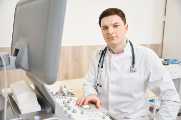 Mladý Lékař Bílém Plášti Stetoskopem Pracuje Vybavení Dívá Kamery Nemocnici — Stock fotografie