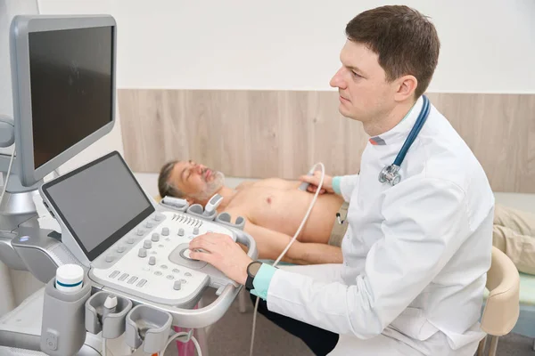 Steteskoplu Beyaz Önlüklü Doktor Klinikteki Hastanın Organlarına Ultrason Teşhisi Koyuyor — Stok fotoğraf