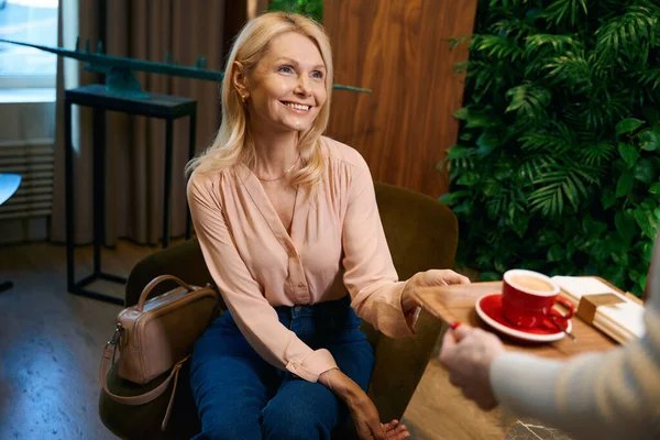 笑顔の女性は美容室でコーヒーのトレイをもたらした 温泉にコーヒーを持ち込まれた女性の写真 — ストック写真