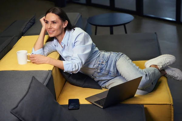 Dreamy Young Corporate Employee Mug Laptop Sitting Sofa Lounge Area — Stock Photo, Image