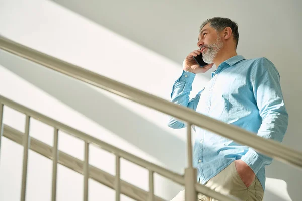白髪の男が階段を登り 電話で話します 現代病院の男 — ストック写真