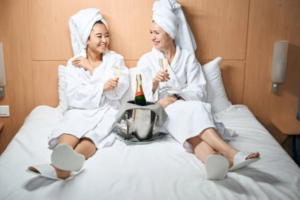 Bornozlu Iki Kadın Otel Odasında Şampanya Içiyor Otel Yatağında Gezimizi — Stok fotoğraf