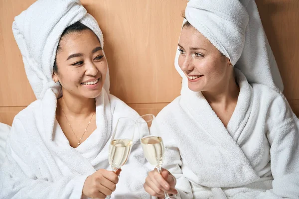 Две Девушки Халатах Кровати Пьют Шампанское Маленькая Вечеринка Номере Отеля — стоковое фото