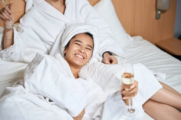 Šťastné Dámy Pijící Šampaňské Hotelovém Pokoji Dvě Přítelkyně Bílých Županech — Stock fotografie