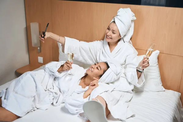 Šťastné Dámy Hotelovém Pokoji Odpočívají Posteli Přítelkyně Baví Oslavovat Výlet — Stock fotografie