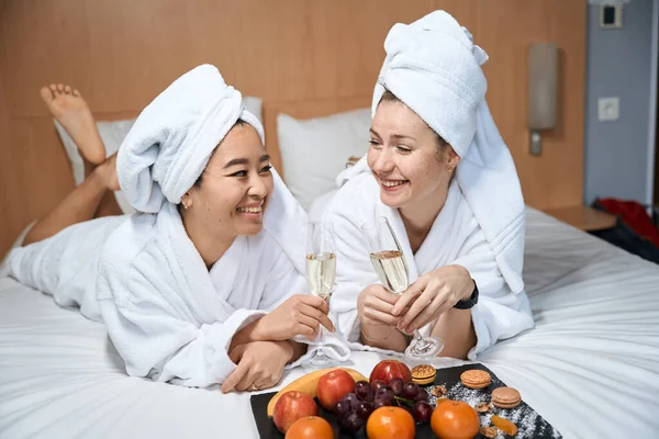 Dos Mujeres Bebiendo Champán Comiendo Fruta Cama Celebrando Viaje Una —  Fotos de Stock