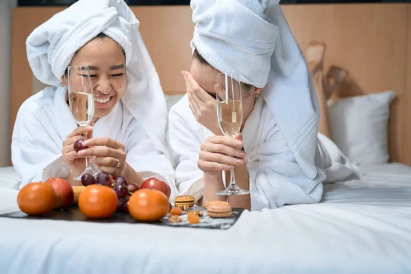 Två Flickvänner Dricker Champagne Med Frukt Vita Rockar Unga Damer — Stockfoto