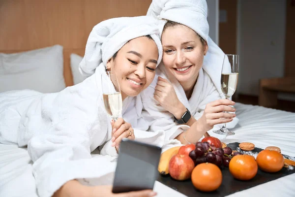 Yatakta Meyve Bardaklarıyla Iki Kız Arkadaşın Fotoğrafı Çekiliyor Bir Otel — Stok fotoğraf