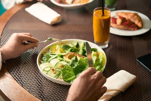 用蔬菜沙拉将男性叉子和刀叉盖在盘子上的剪影 — 图库照片