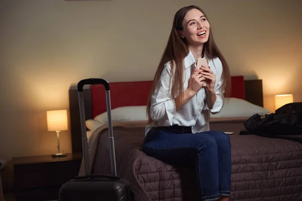 Otel Odasında Büyük Bir Yatakta Oturup Gülen Genç Güzel Bir — Stok fotoğraf
