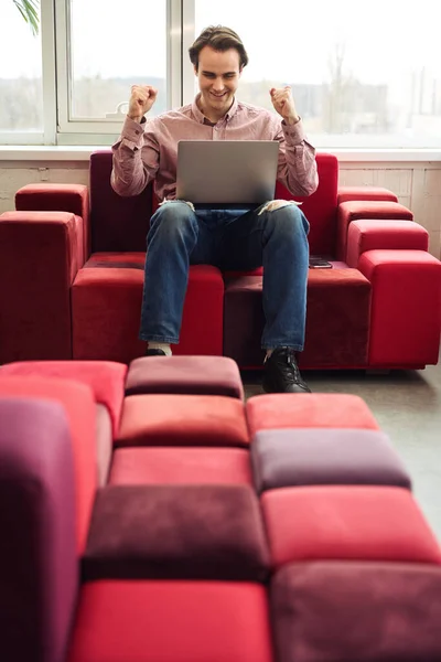 Exultant Company Employee Seated Sofa Modern Office Looking Computer Monitor — Stock Photo, Image