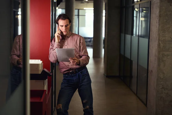 Ernsthaft Fokussierter Büroangestellter Steht Neben Kopierer Während Während Eines Telefonats — Stockfoto