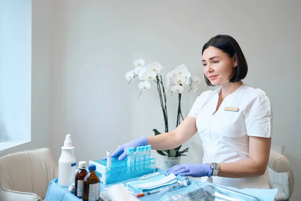 Vrouwelijke Dermatoloog Handschoenen Zittend Kosmetologie Kantoor Voor Medische Spullen Bureau — Stockfoto
