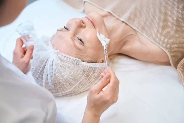 Kosmetikerin Bereitet Sich Auf Kosmetischen Eingriff Auf Reifes Damengesicht Vor — Stockfoto
