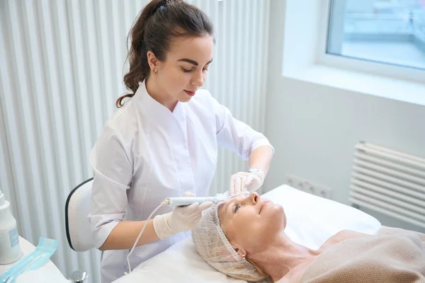 Medizinische Kosmetikerin Macht Kosmetische Gesichtsreinigung Für Erwachsene Dame Schönheitssalon — Stockfoto