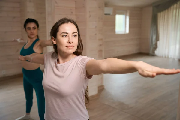 穿着运动服的年轻妇女站在一起 在家里做着平衡运动 — 图库照片