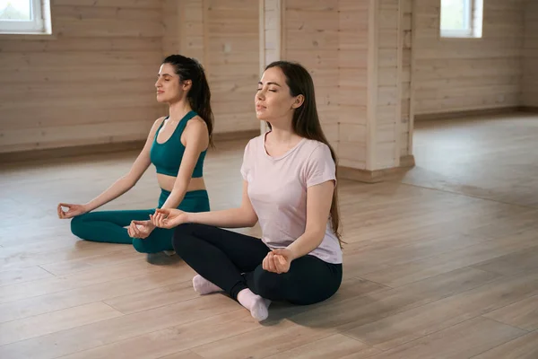 Female Friends Tracksuits Sitting Next Each Other Lotus Position Resting — Stock Photo, Image