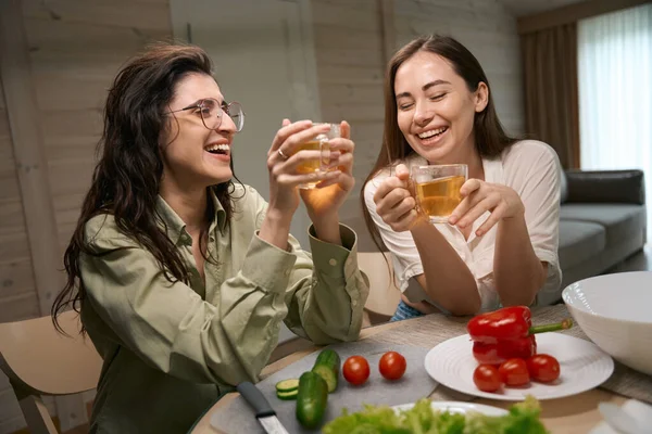 快乐的朋友们坐在桌旁 举着杯子 在厨房里聊天 — 图库照片