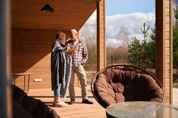 Romantik Çift Kır Evinin Terasında Dikilirken Cam Fincanlarını Tokuşturuyorlar — Stok fotoğraf