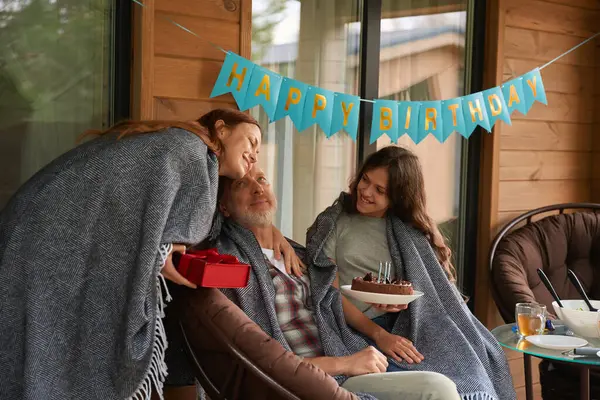 誕生日人で椅子に座っています上のベランダ取得プレゼントから陽気な十代の女の子と笑顔女性 — ストック写真