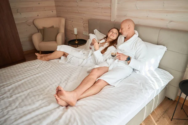 Tevreden Vrouw Haar Echtgenoot Liggen Bed Met Kopjes Cafeïnehoudende Dranken — Stockfoto