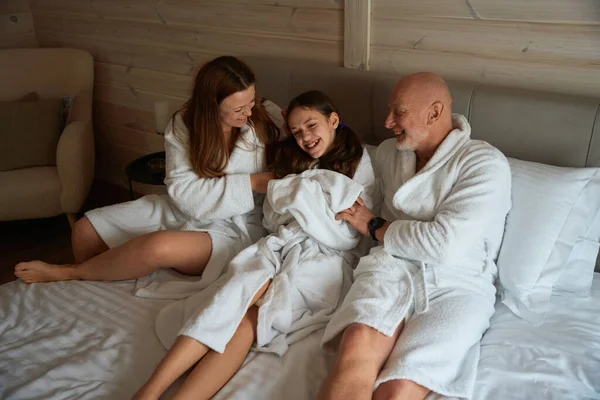 사랑많은 부모에게 둘러싸여 침대에 즐거운 사춘기 — 스톡 사진