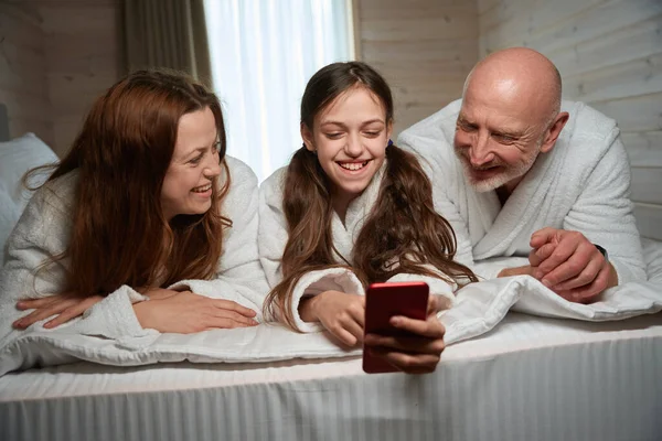 Joyous Dotter Ligger Sängen Sällskap Med Föräldrar Visar Selfies Sin — Stockfoto