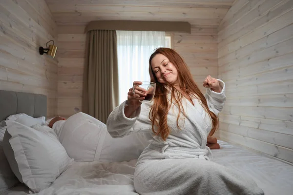 Glimlachende Dame Met Kopje Cafeïnevrije Drank Hand Stretching Bed Terwijl — Stockfoto