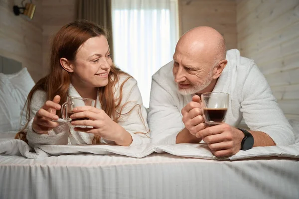 Happy Couple Lying Bed Cups Caffeinated Beverage Hands — Stock Photo, Image