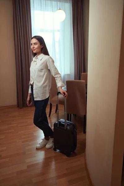 Junge Dame Hotelzimmer Mit Einem Koffer Vor Einem Vorgehängten Fenster — Stockfoto