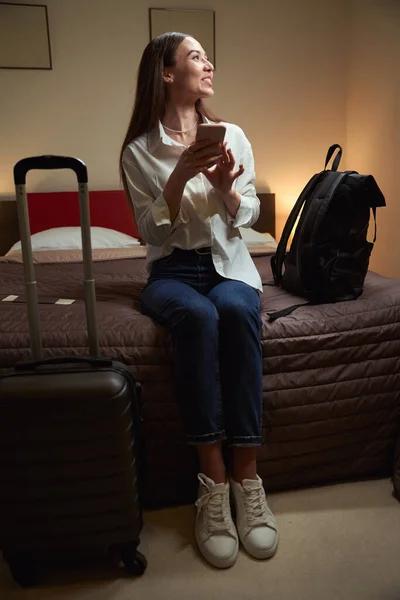 Kanepede Bavuluyla Oturan Elinde Telefon Tutan Güzel Bir Genç Kadın — Stok fotoğraf