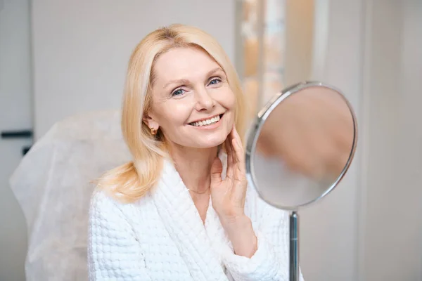 Happy Mature Woman Sitting Mirror Touching Her Face One Hand — Stock Photo, Image