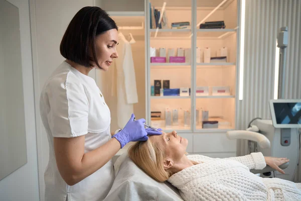 Cosmetologist Que Faz Injeção Interbrow Maduro Mulher Salão Beleza — Fotografia de Stock
