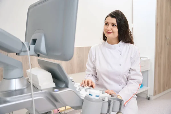 Beyaz Önlüklü Genç Bayan Kardiyolog Klinikteki Dolapta Ekipman Üzerinde Çalışıyor — Stok fotoğraf