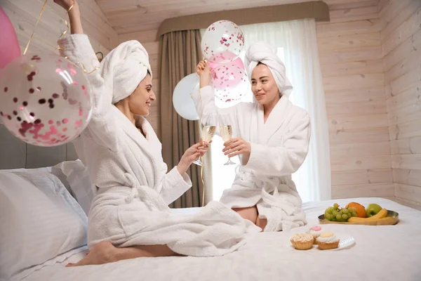 Neşeli Mutlu Kadınlar Bornoz Giyip Otel Odasında Büyük Bir Yatakta — Stok fotoğraf