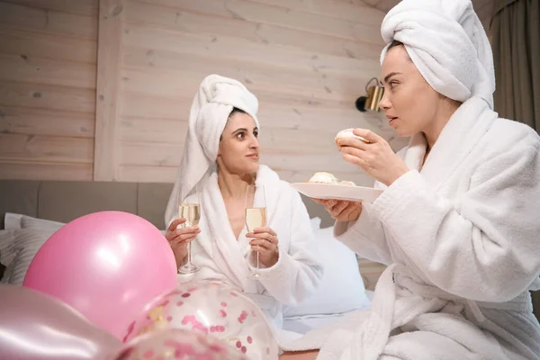 Веселі Жінки Халаті Лежать Великому Ліжку Готельному Номері Тримаючи Торти — стокове фото