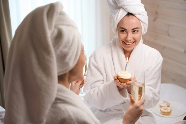 Beyaz Bornozlu Gülümseyen Güzel Kadınlar Büyük Otel Yatağında Oturmuş Ellerinde — Stok fotoğraf