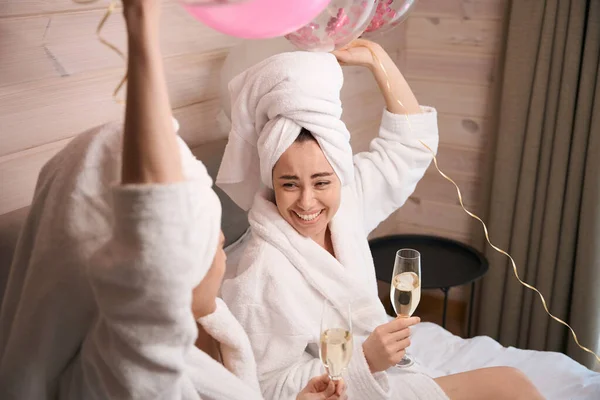 Balonlu Şampanyalı Iki Mutlu Kadın Büyük Yatakta Oturmuş Bekarlığa Veda — Stok fotoğraf