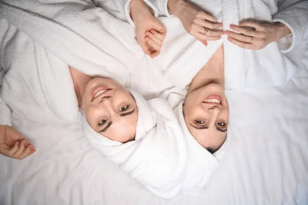 Portrait Deux Femmes Peignoirs Blancs Allongées Lit Satisfaites Des Soins — Photo
