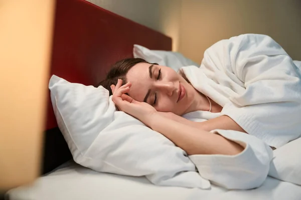 穏やかなリラックスした白人女性嘘で閉じられた目で彼女の快適なベッドの間に睡眠 — ストック写真