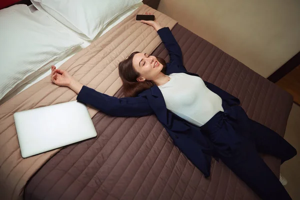Jonge Vrouw Business Suit Met Smartphone Haar Hand Ligt Bed — Stockfoto