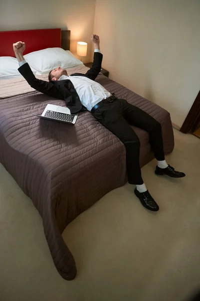 Счастливый Человек Деловом Костюме Лежит Кровати Возле Компьютера Радуется Отдыху — стоковое фото