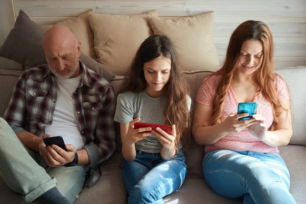 Ungdoms Flicka Och Hennes Föräldrar Sitter Soffan Rummet Med Smartphones — Stockfoto