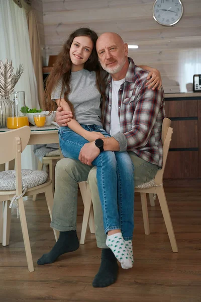 Smiling Adolescent Girl Hugging Her Calm Father While Sitting His — Stock Photo, Image