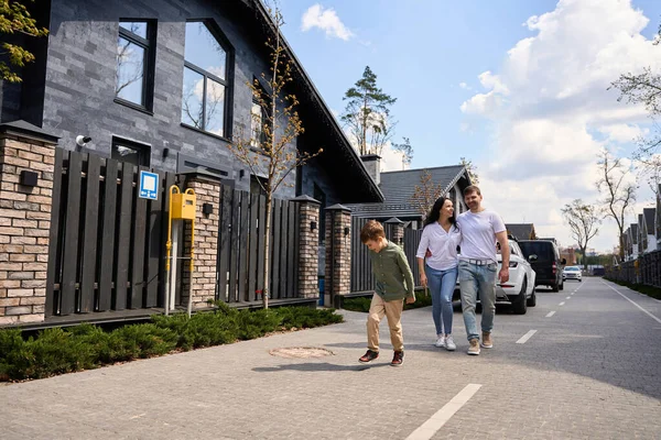 stock image Young couple and their baby enjoy the view of the street with beautiful houses