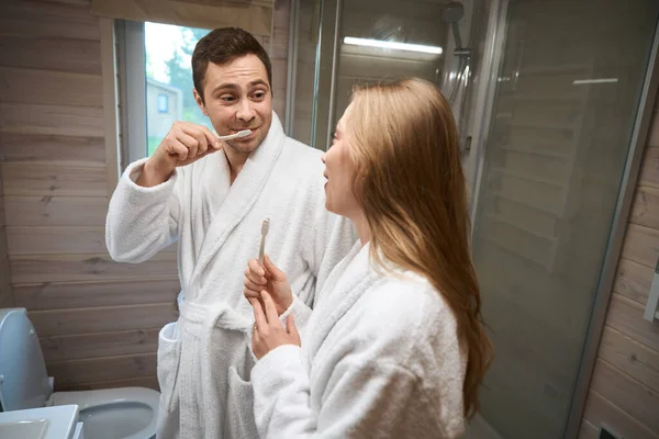 Muž Čistí Zuby Dívá Ženu Zatímco Stojí Koupelně — Stock fotografie