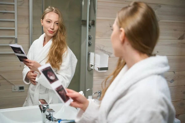 Žena Která Dívá Zrcadla Koupelně Drží Ruce Fotku Ultrazvuku Těhotenství — Stock fotografie