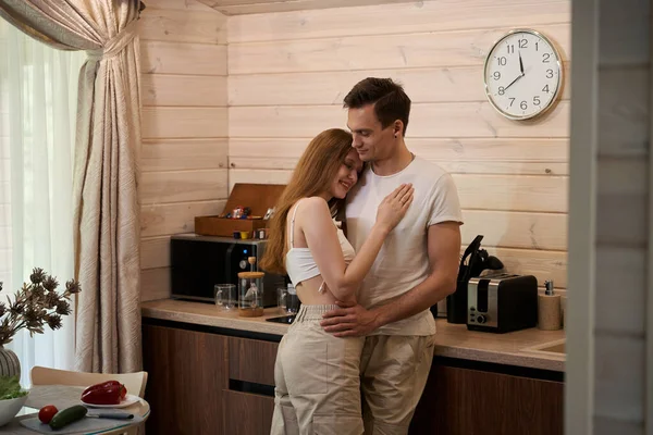 Young Couple Stands Kitchen Embrace Man Looks Lady — Stock Photo, Image