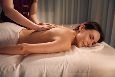 Masöz avucu sırtına bastırırken gözleri kapalı bir şekilde uzanan kaplıca istemcisi