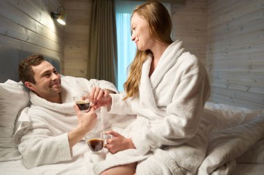 Minnettar bir adam taze kahve içiyor sevgili karısının yaptığı ve gülümsediği kırsalda mutlu bir hafta sonu geçiren mutlu bir çift.